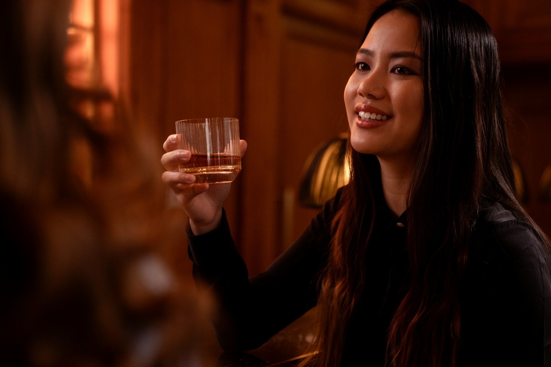 a woman holding a glass of wine in her hand